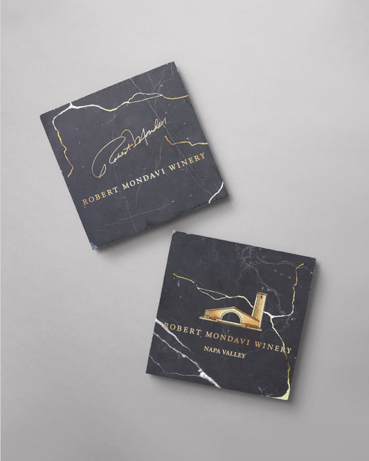 Handcrafted Black and Gold Marble Coasters with the Robert Mondavi Winery logo on it in gold